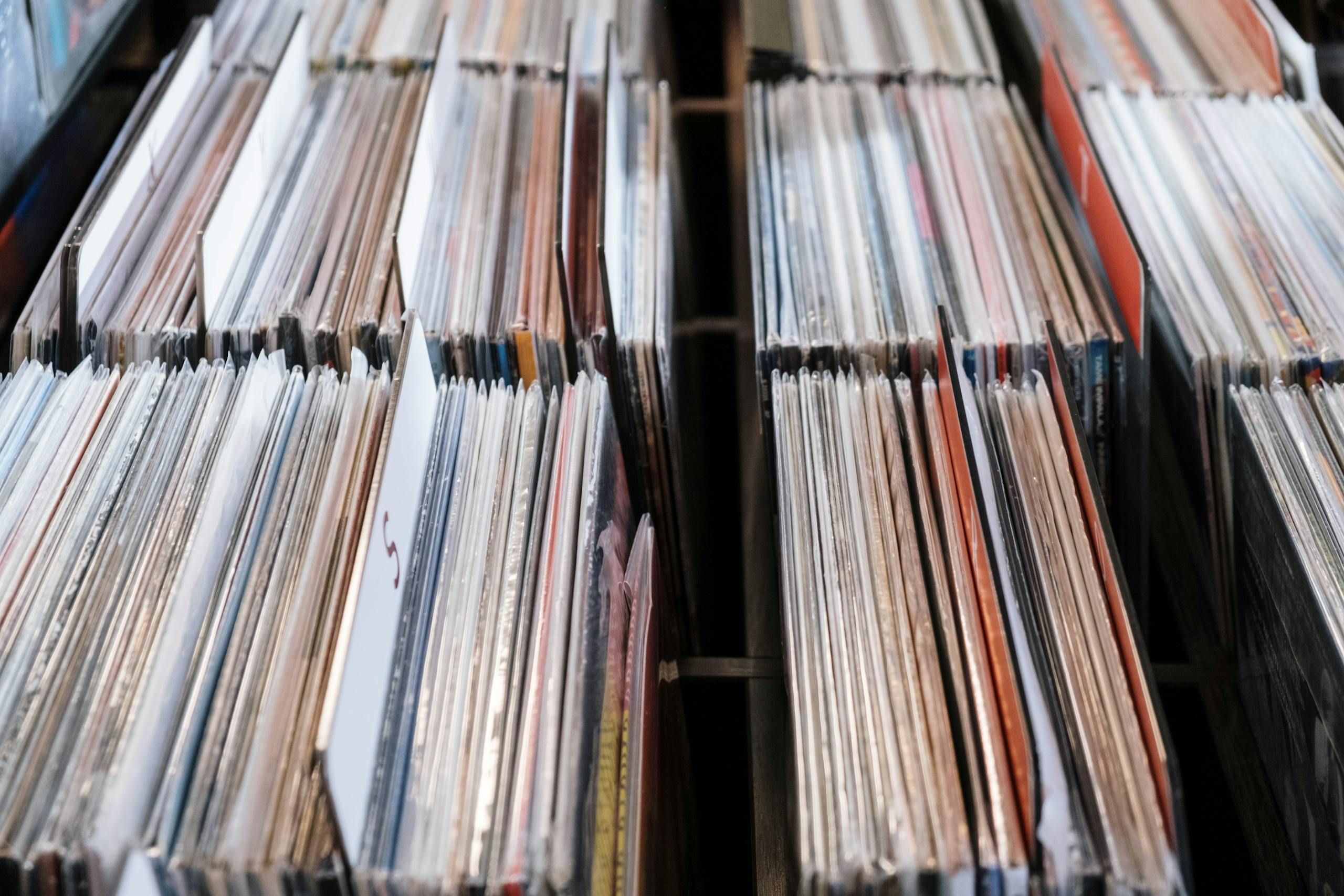 Close-up view of vintage vinyl records in a store setting, showcasing a retro music collection.